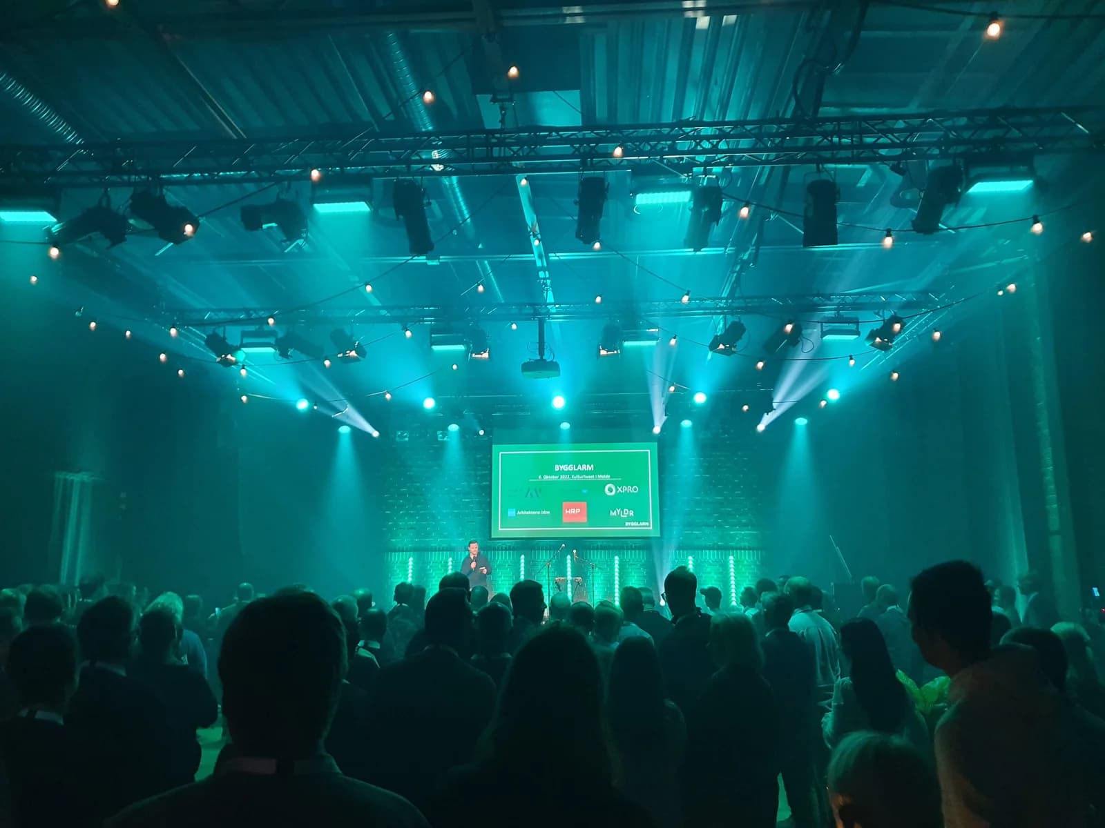 Publikum foran en opplyst scene på Bygglarm 2022.