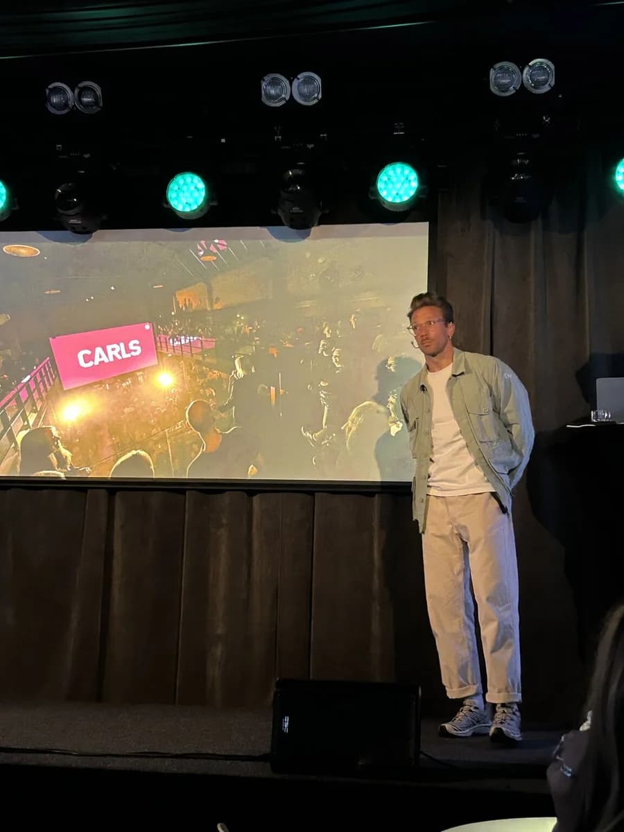En foredragsholder på scenen foran en presentasjon med Carls-logo.
